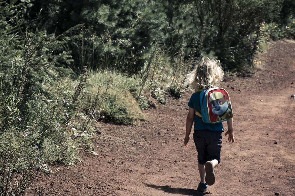 Reportage famille : parent avec leurs deux enfants lors d'une randonnée sur les volcans. Crédit : Anthony M. Photographe